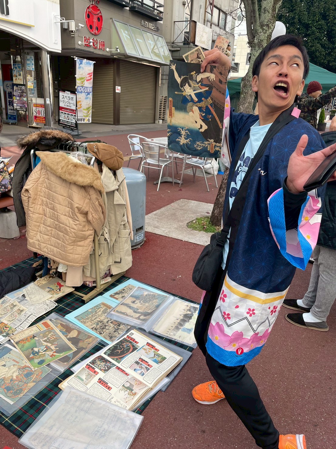 フリーマーケットで掘り出し物の浮世絵を見つけて喜ぶ来場者