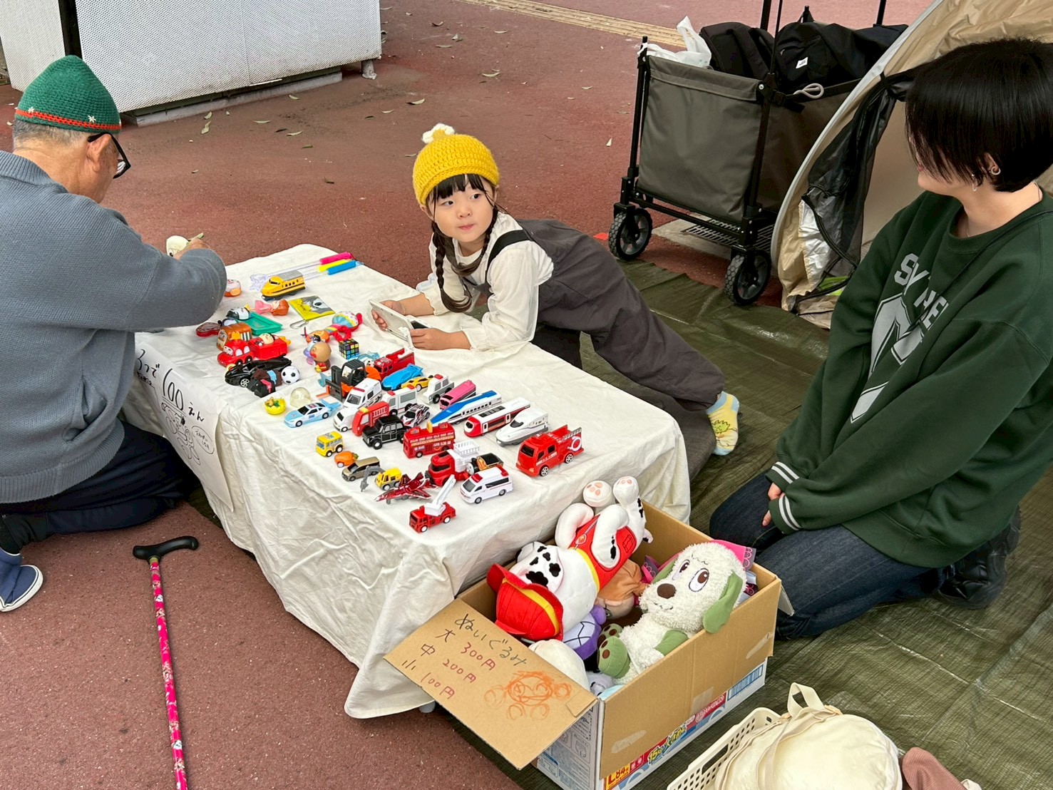 親子でおもちゃを販売する微笑ましいフリーマーケットの風景